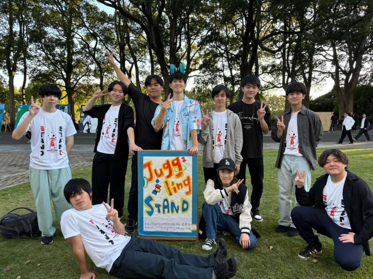 ジャグリングの看板を囲むSTANDのメンバーたち